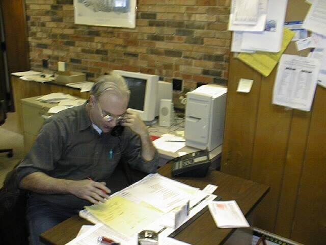 Tim Dolan reading paperwork at an office desk
