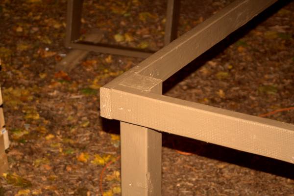 Close-up of the corner joinery on a painted brown rabbit cage stand