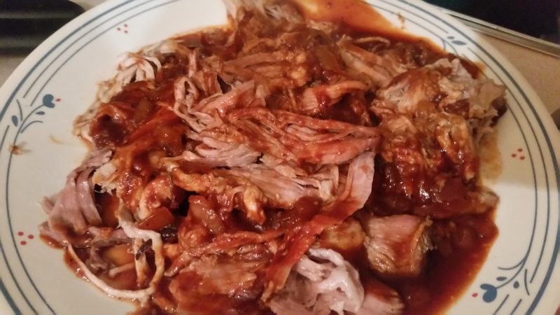 A plate of pulled pork mixed with barbecue sauce