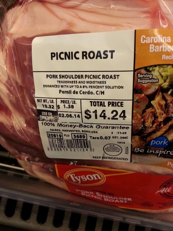 A Tyson pork shoulder picnic roast in store packaging with a price tag