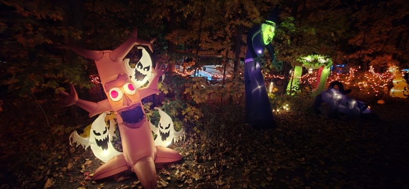 Inflatable scary tree with ghost faces, a purple reaper, and a green witch