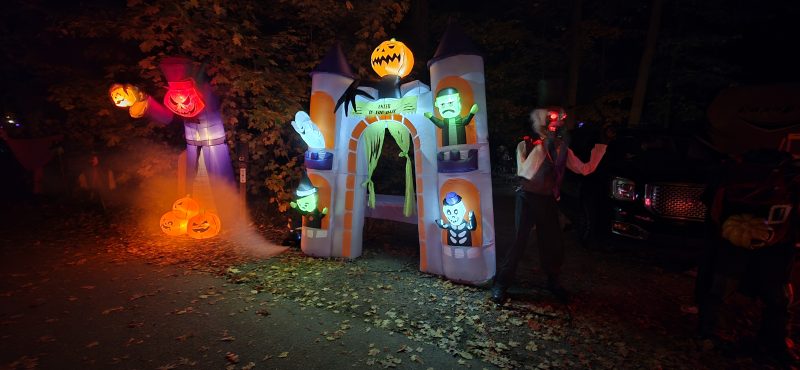 Inflatable haunted castle archway with monsters and orange fog along the path